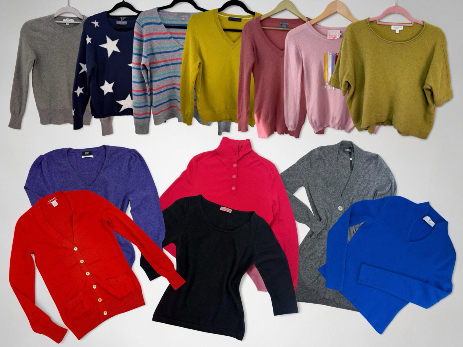 Sixteen cashmere jumpers and cardigans laid out together in many colours