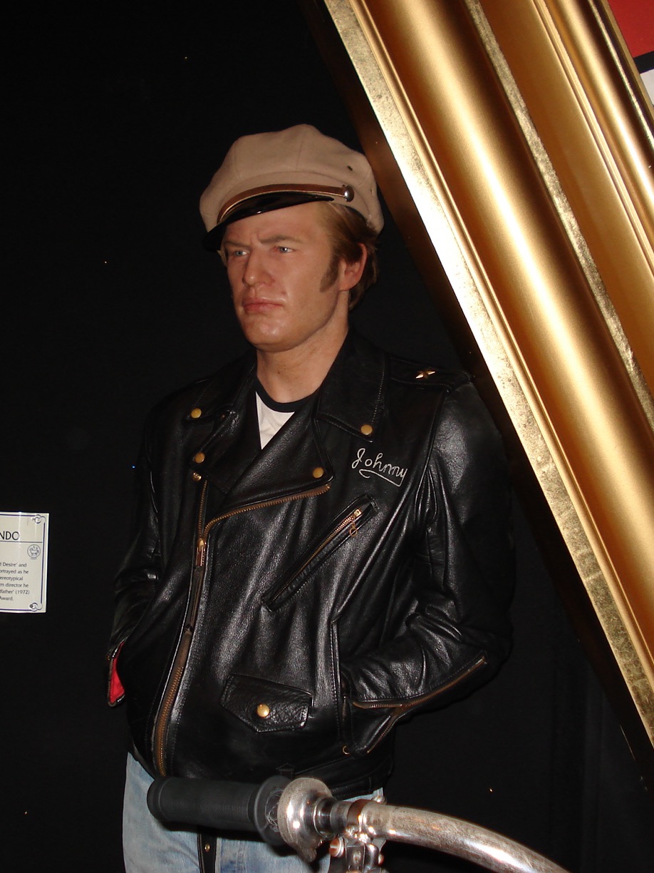A wax figure of Marlon Brando as Johnny in The Wild One, in a black leather biker jacket with an off-centre zip and a peaked cap
