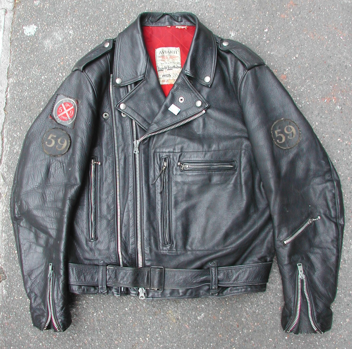 A vintage black Lewis Leathers Aviakit Bronx motorcycle jacket with a red quilted lining, zipped cuffs, a belt and round 59 patches
